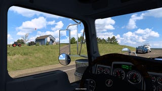 An idyllic farmhouse out the window of a truck cab in American Truck Simulator.